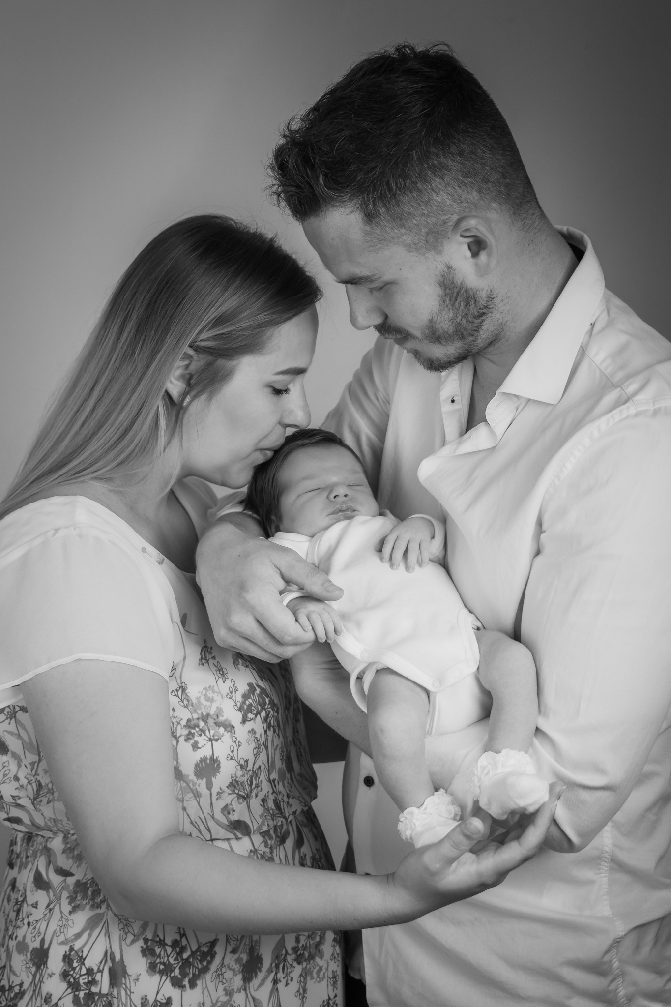 radost z miminka, černobílá fotka, novorozenecké focení, newborn v ateliéru, polibek, šťastné dítě